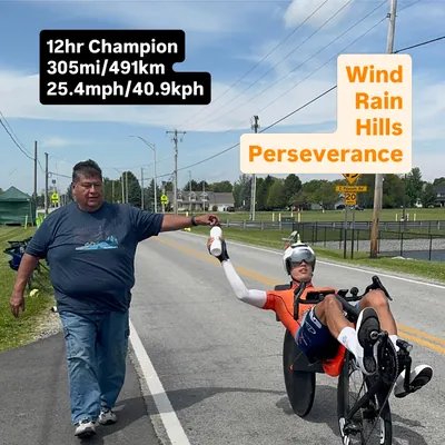Matthew Lefthand on his Cruzbike taking a bottle from a supporter, 12 hour North American champion